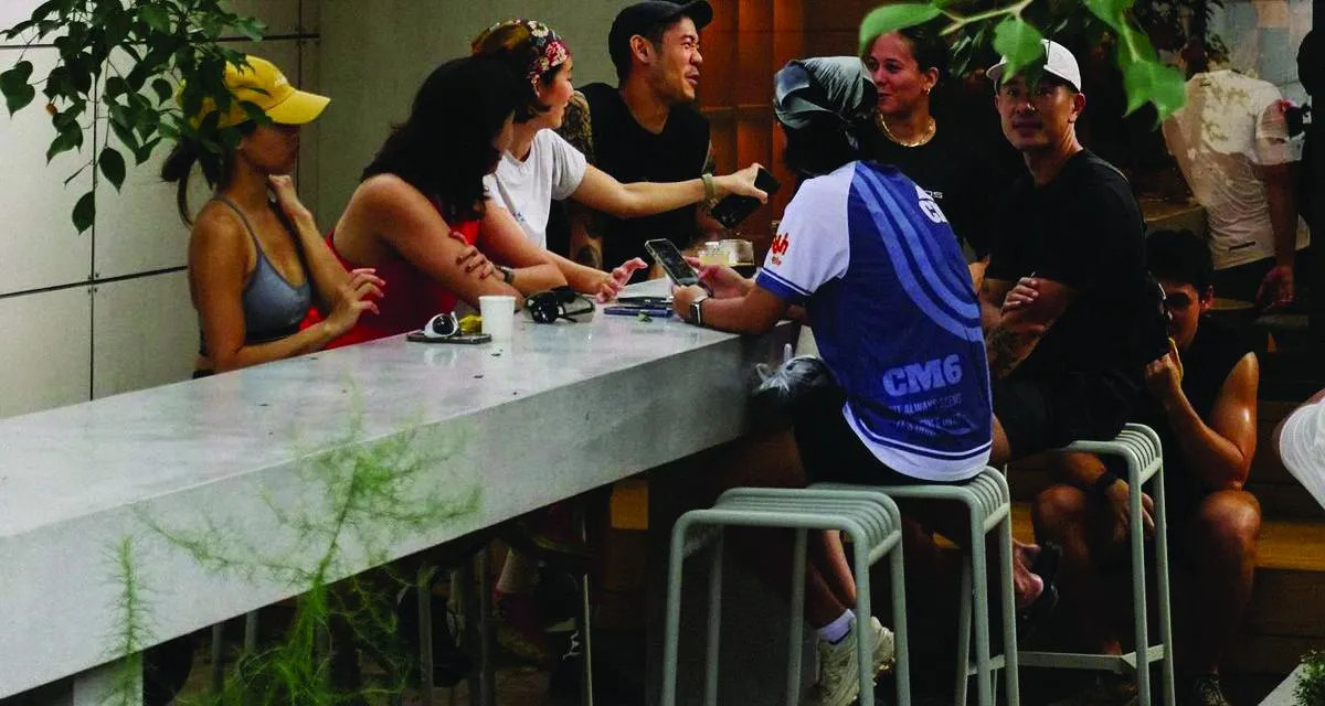 Friends talking around a counter in a leafy courtyard