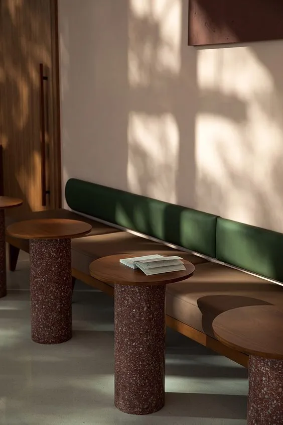 A sunlit lounge with timber tables and a banquette